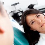 Woman with Pain Holding Her Jaw in Dentist Chair Kennesaw GA