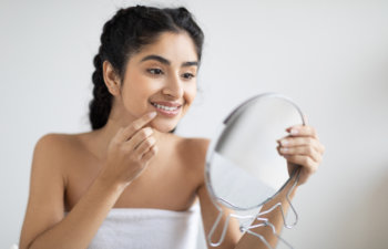 satisfied woman touching her lips looking in the mirror