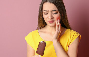 girl has hypersensitive teeth eats ice cream